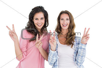 Portrait of two young female friends gesturing peace sign