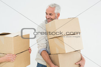 Smiling mature man carrying boxes