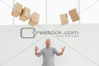 Annoyed mature man with falling boxes