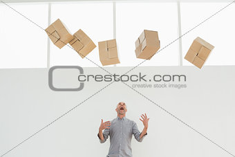 Annoyed mature man with falling boxes