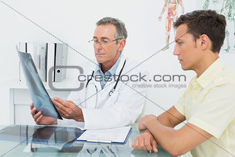 Doctor explaining lungs x-ray to patient in office