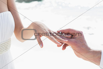 Man placing ring on brides finger
