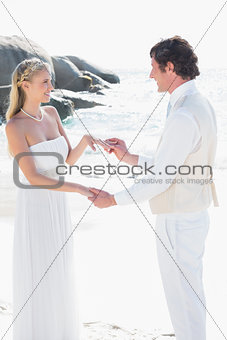Man placing ring on pretty brides finger