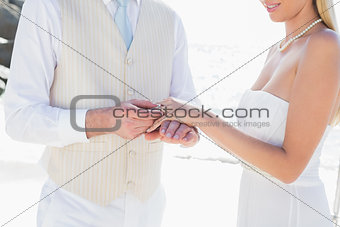 Man placing ring on smiling brides finger
