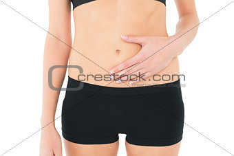 Close-up mid section of a fit woman with stomach pain