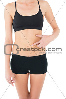 Close-up mid section of a fit woman with hand on stomach