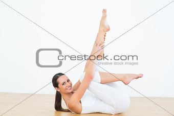 Fit woman stretching body in fitness studio