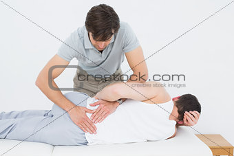 Male physiotherapist examining mans back