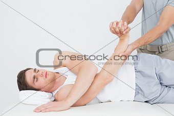 Male physiotherapist examining a young mans hand