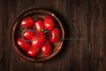Tomatoes on the grunge wooden background