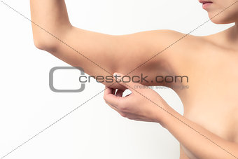 Woman testing the flabby muscle under her arm