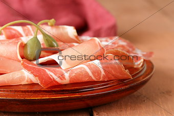 sliced ​​dried sausage meat (ham, prosciutto, salami) served on a wooden board