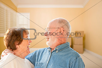 Happy Senior Couple In Room with Moving Boxes on Floor