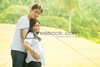 Happy young pregnant Asian couple