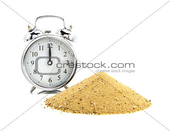 Alarm clock with pile of sand  of white background