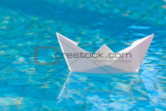 White paper boat floating in the water