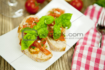 fresh tasty italian bruschetta with tomato on table