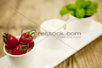 tasty tomatoes mazarella and basil on plate on table