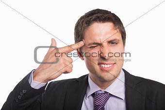 Businessman holding fingers against temple in gun gesture