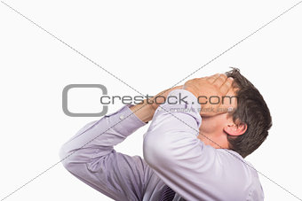 Worried businessman with hands covering face