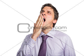 Young businessman in shirt and tie yawning