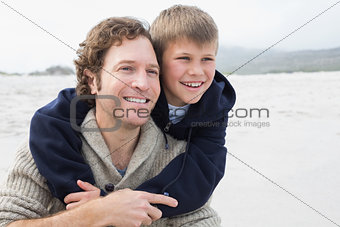 Man piggybacking his son at beach