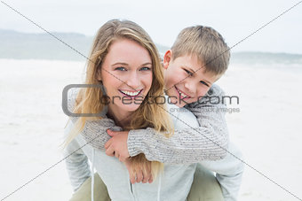 Woman piggybacking her son at beach