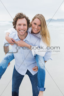 Portrait of a man piggybacking woman at beach