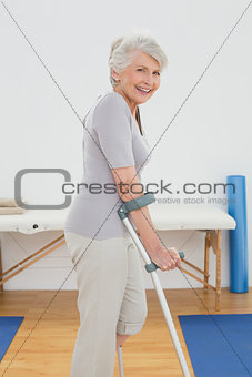 Side view of a smiling senior woman with crutches