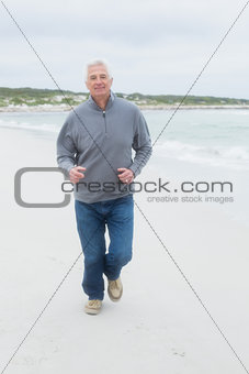 Full length of a senior man running at beach
