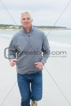 Portrait of a senior man running at beach