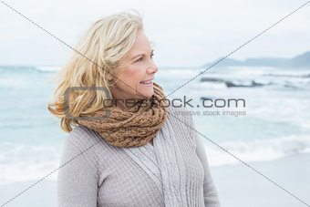 Contemplative senior woman looks away at beach