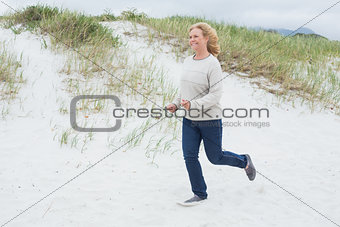Happy senior woman running at beach