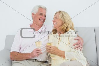 Senior couple with champagne flutes at home