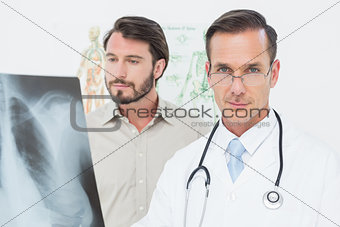 Portrait of a male doctor and patient with lungs x-ray