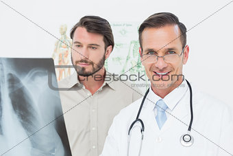 Portrait of a male doctor and patient with lungs x-ray