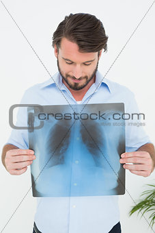 Smiling young man holding lung x-ray