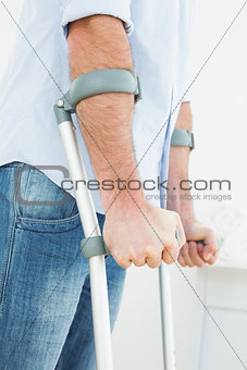 Close-up mid section of a young man with crutches