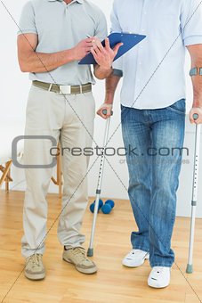 Therapist and disabled patient with reports