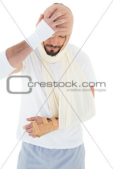 Man with head tied up in bandage and broken hand