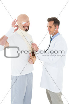 Doctor auscultating a patient tied up in bandage with stethoscope