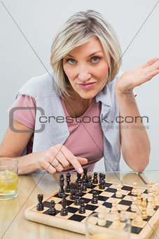 Portrait of a woman playing chess at table