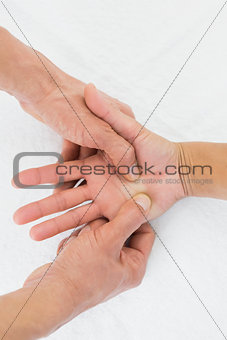 Doctor examining a female patient's palm