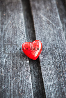 Red heart on the shabby wooden board