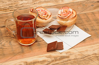 Apple cakes with cup of tea like flower on wooden table