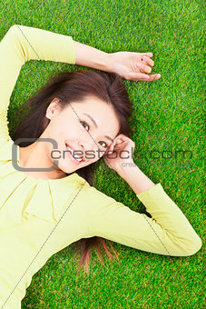 young woman lying in the park meadow
