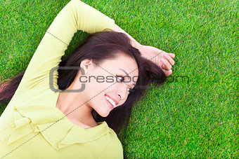 young woman lying and looking side in a meadow