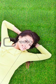 beautiful young woman laying down in park