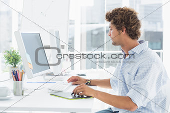 Male artist drawing something on graphic tablet with pen