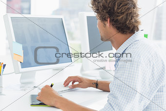 artist drawing something on graphic tablet with pen